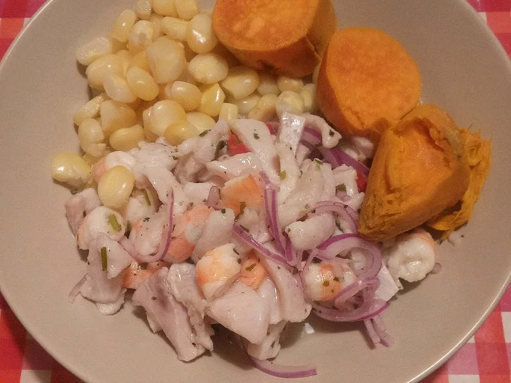Ceviche mixto con mariscos, camote y choclo