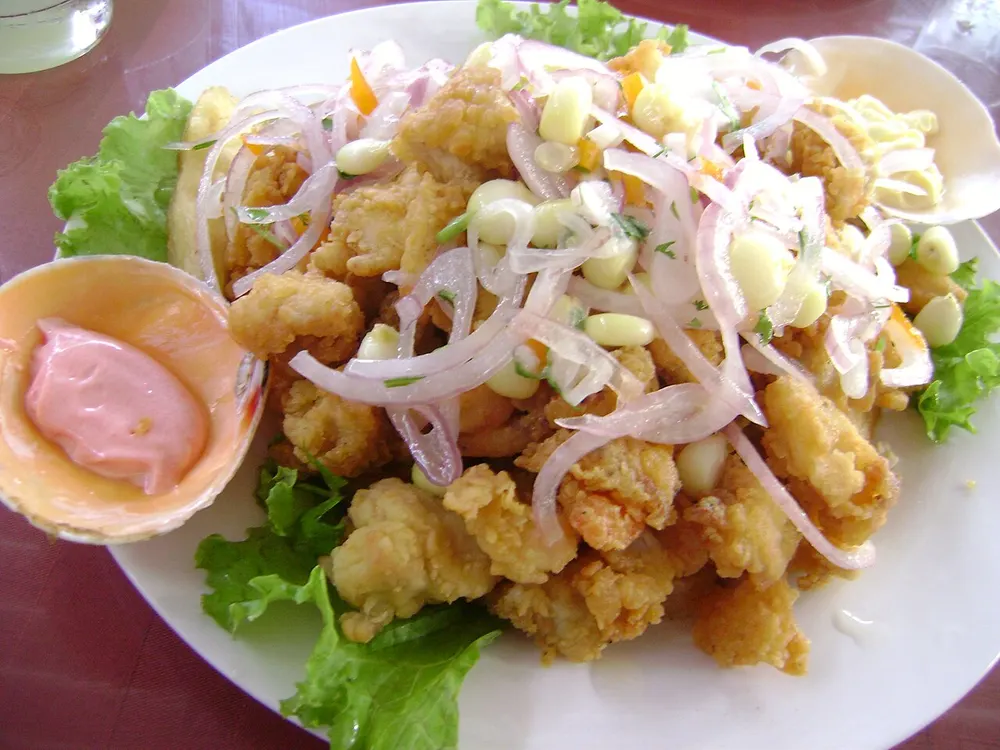 Jalea mixta de pescado y mariscos fritos con salsa criolla