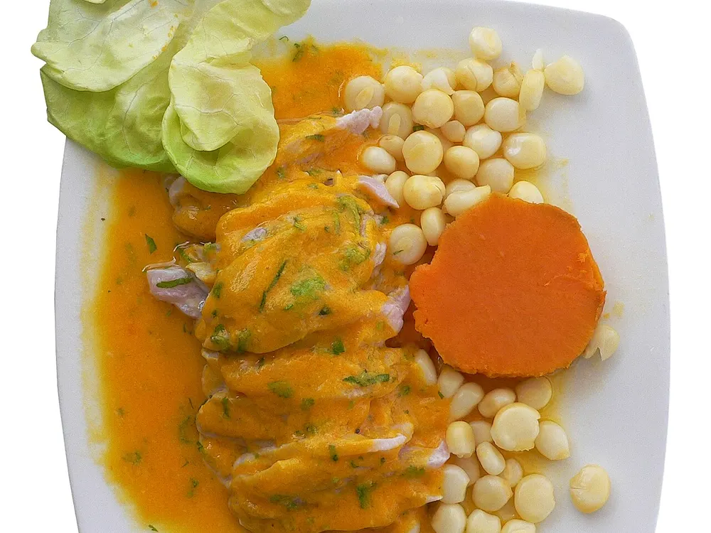 Tiradito de pescado en crema de ají amarillo con choclo y camote